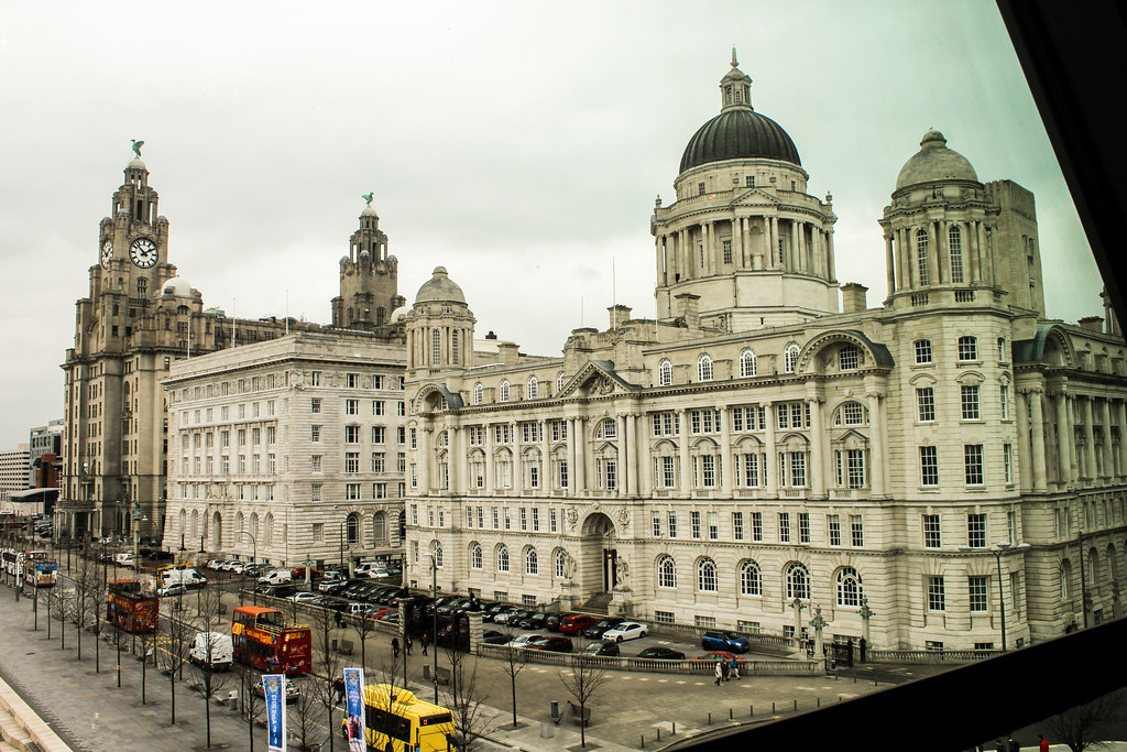 Edificios icónicos del Pier Head en Liverpool vistos desde una ventana.