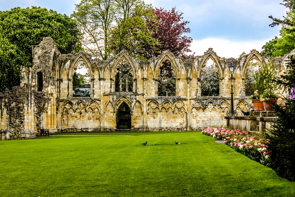 Ruinas de la abadía con arcos ojivales y jardines floridos en York.