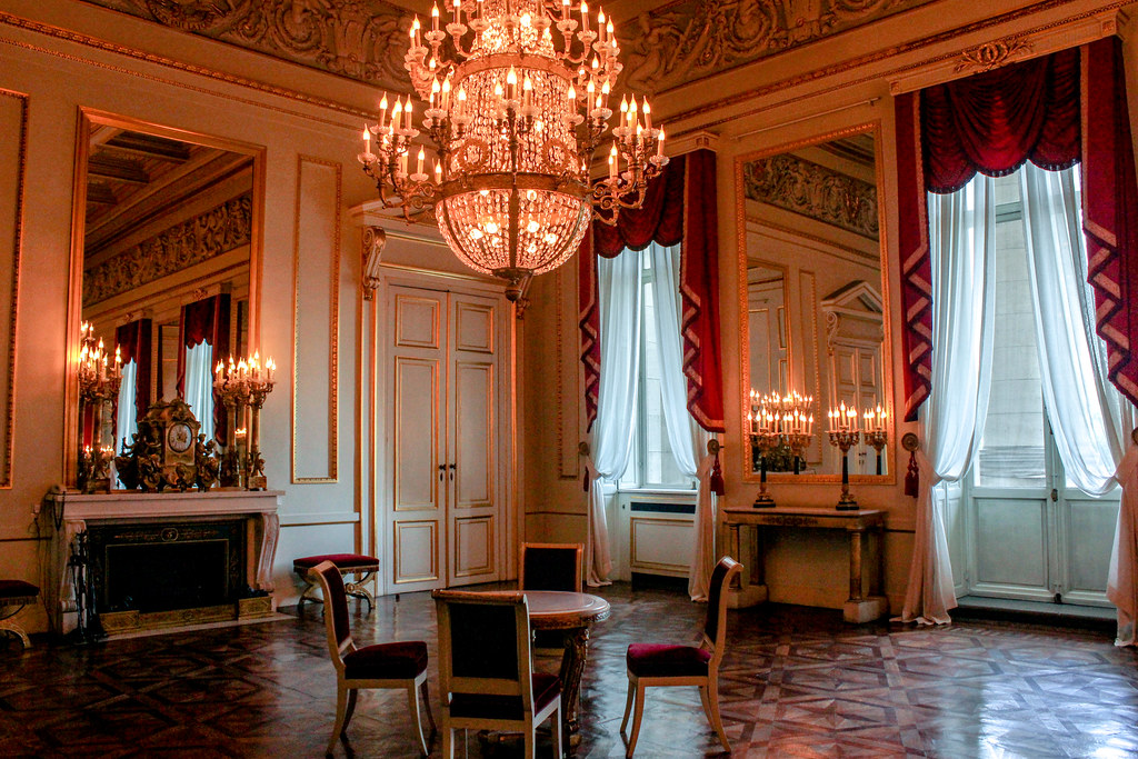 Sala de recepciones del Palacio Real con candelabros, espejo ornamentado y cortinas rojas, Bruselas, Bélgica.