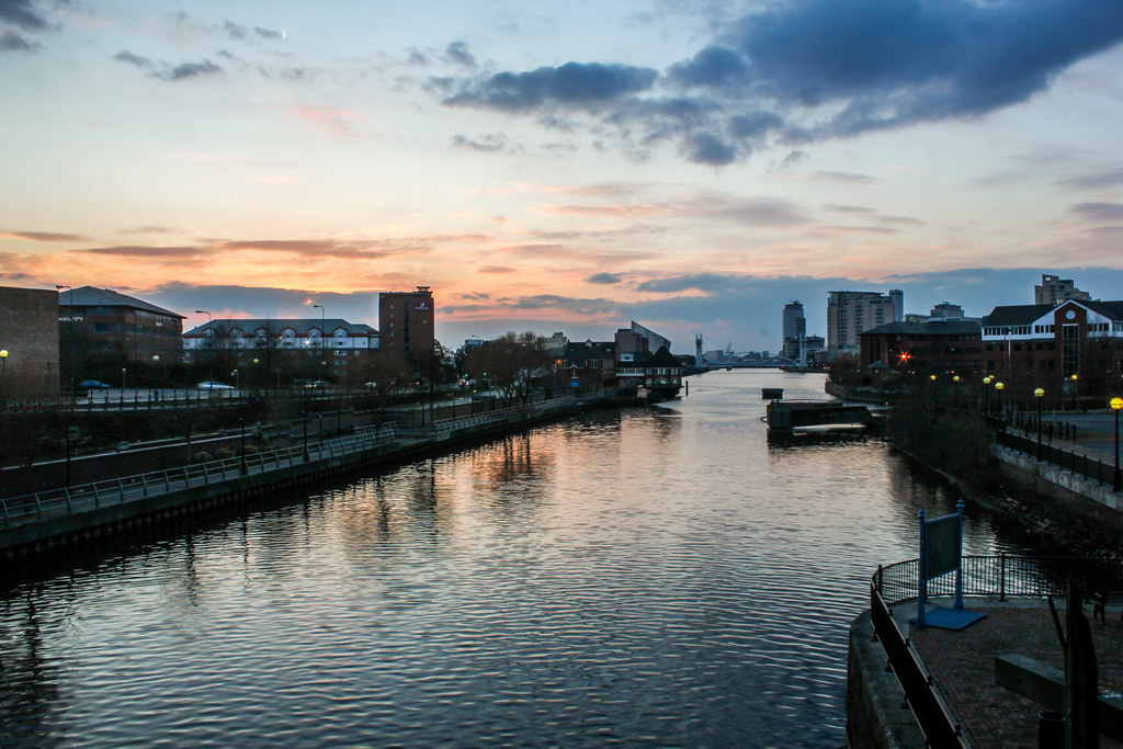Vista del atardecer en Salford Quays, Manchester, con reflejos sobre el agua.