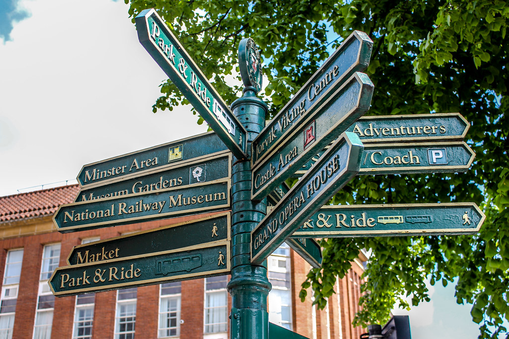 Señalización direccional en York mostrando atracciones turísticas.