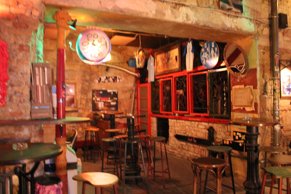 Interior desenfocado del bar Szimpla Kert en Budapest con decoración ecléctica.