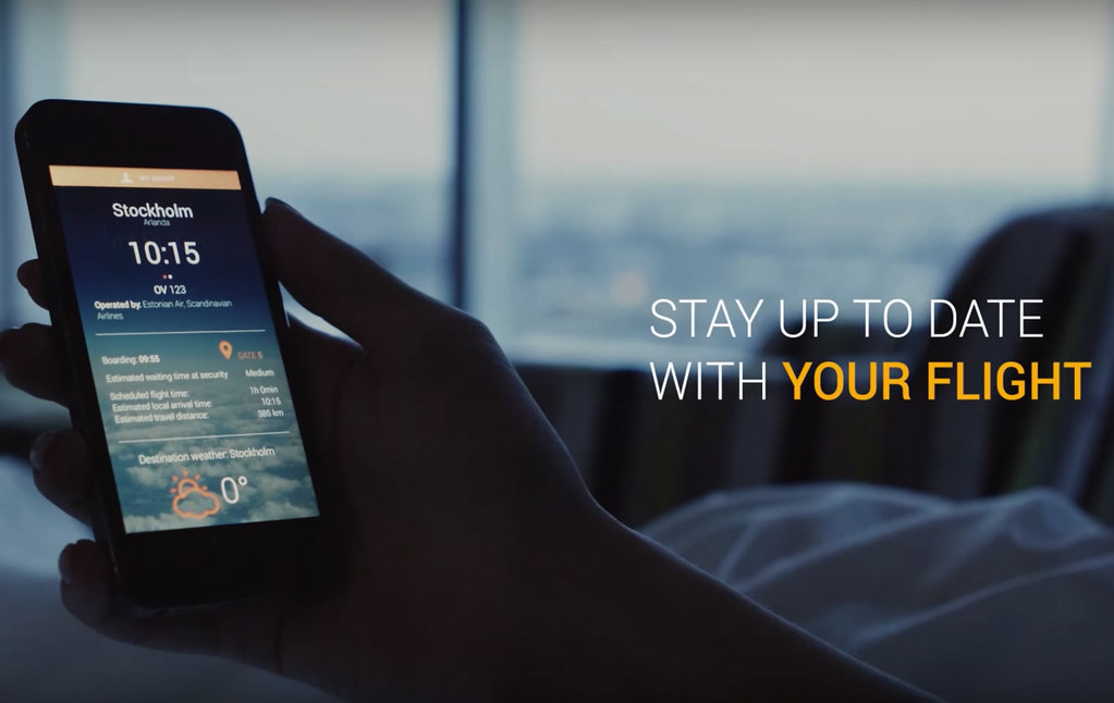 Usuario revisando detalles de vuelo y clima en Estocolmo a través de una app de aeropuerto en su teléfono móvil.