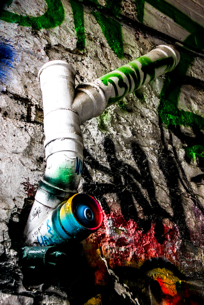 Tubería de drenaje pintada sobre fondo de graffiti en Werregarenstraat, Gante.