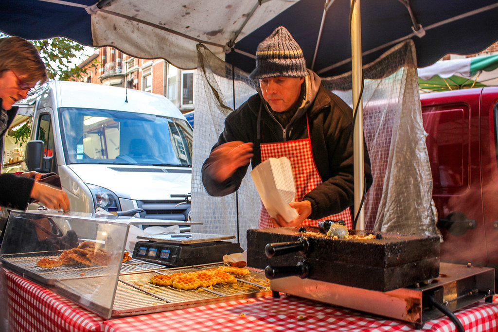 Vendedor preparando gofres belgas en un puesto callejero en Lovaina.