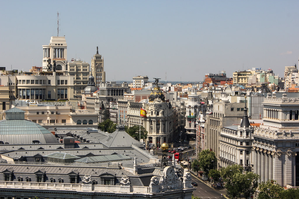 Vista aérea de la Gran Vía y el Metrópolis en Madrid con arquitectura emblemática.