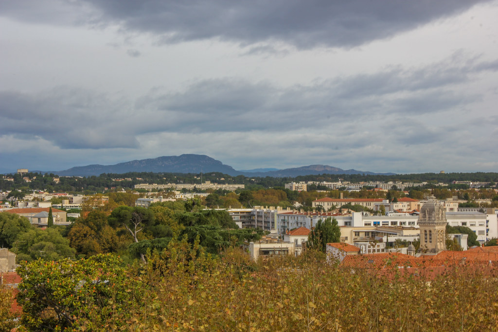 Vista panorámica de Montpellier con el paisaje montañoso al fondo en un día nublado.