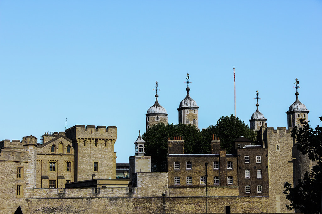 Vista de la Torre de Londres con las emblemáticas torretas y la bandera británica.