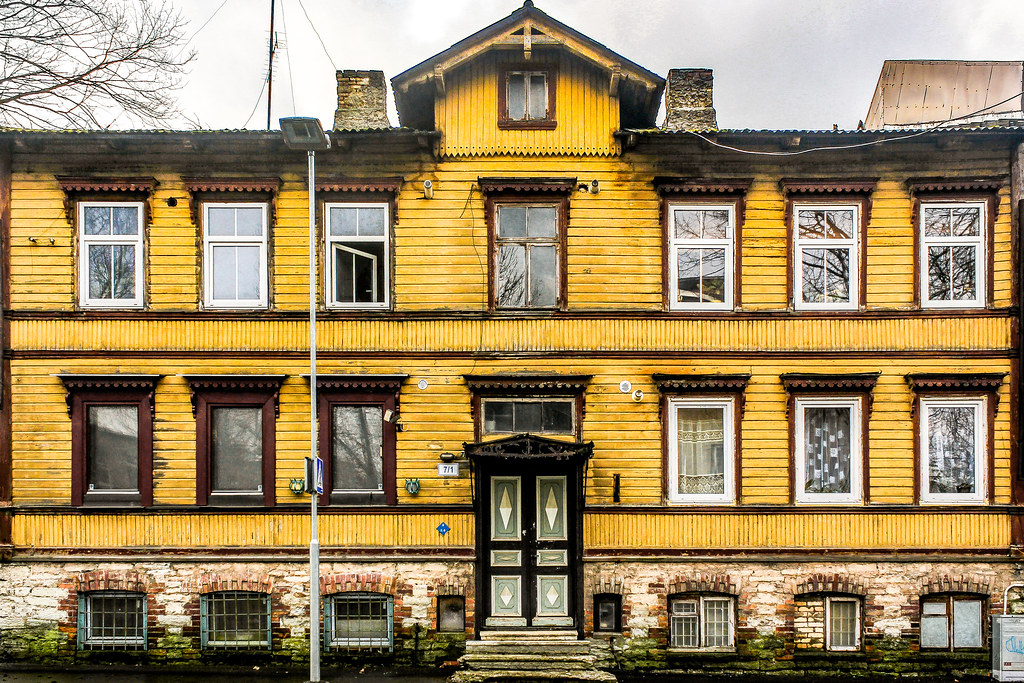 Vivienda de madera amarilla en Kalamaja, Tallin, con base de piedra expuesta.
